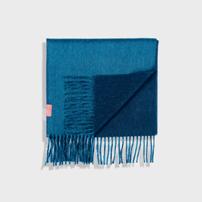 Blue scarf with fringes on a light gray background