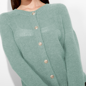 Green knitted cardigan with button details on a white background