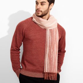 Man wearing a red sweater and pink scarf against a white background