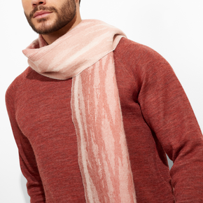 Man wearing a red sweater and pink scarf against a white background