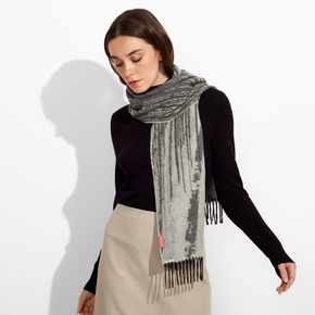 Woman wearing a gray scarf with fringe on a white background