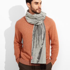 Man wearing a rust-colored sweater and gray scarf against a white background