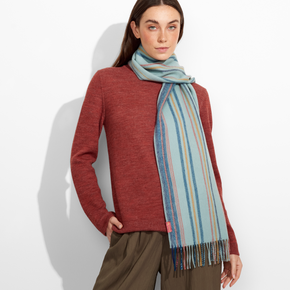 Woman wearing a red sweater and striped scarf against a white background
