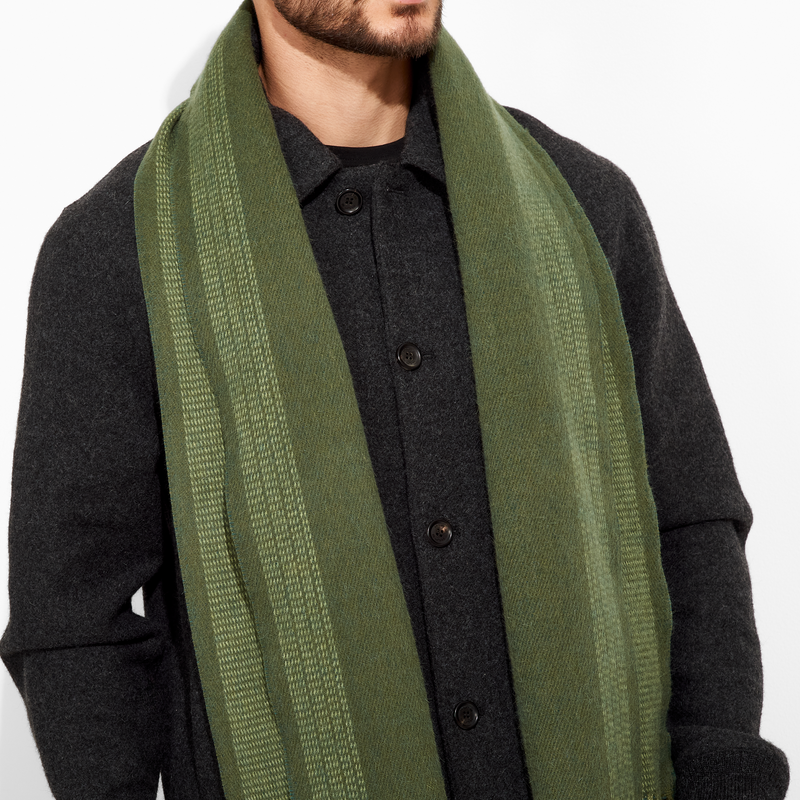 Person wearing a green scarf with a plain background