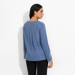 Woman wearing a blue sweater against a white background