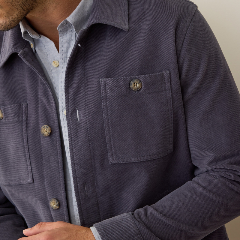 Navy blue shirt with button details on a neutral background