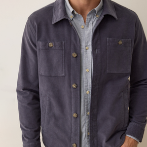 Navy jacket over a light blue shirt on a neutral background