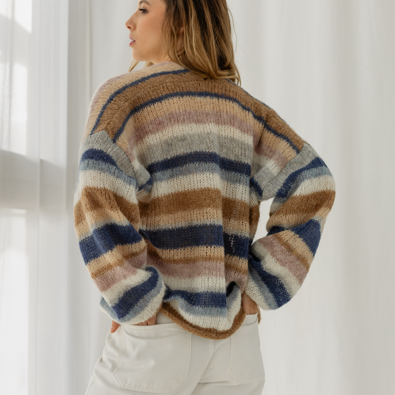 Woman wearing a striped sweater in a bright room