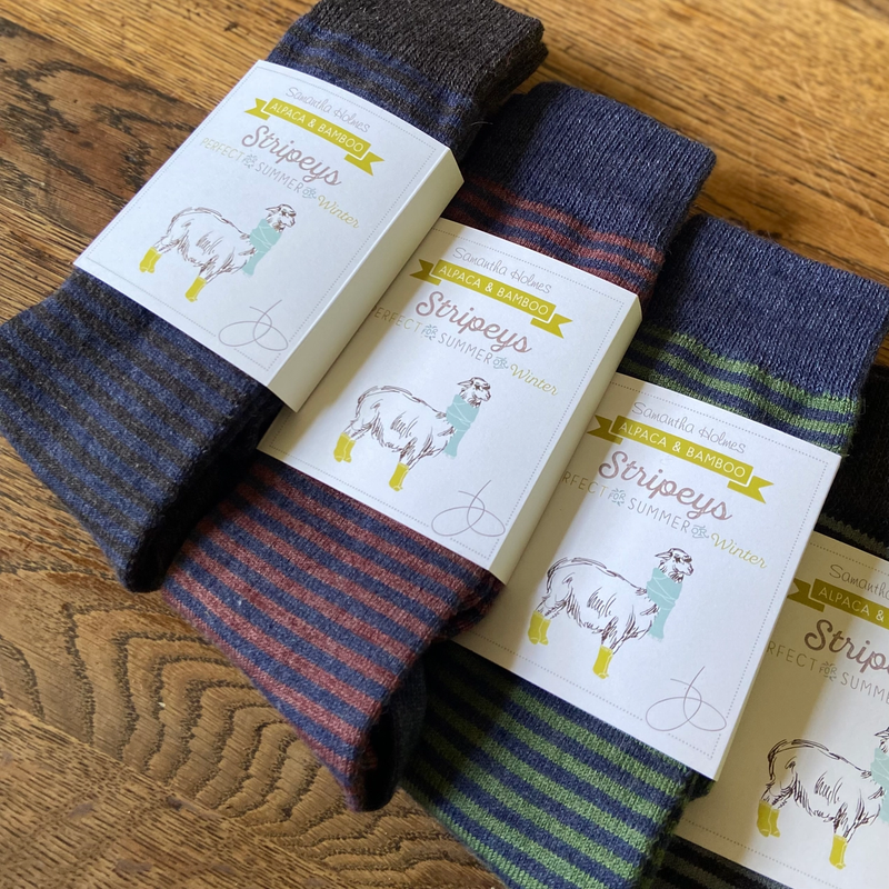 Striped socks with packaging on a wooden surface