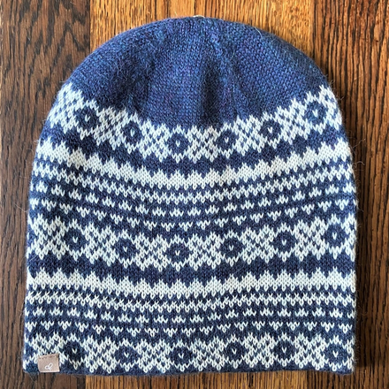 Blue and white patterned knit beanie on a wooden surface