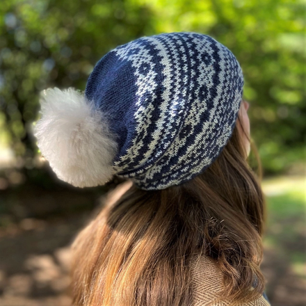 woman wearing blue fair isle patterned hat with pom pom