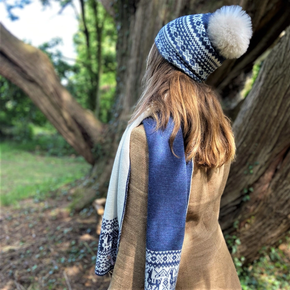 woman wearing blue fair isle patterned hat with pom pom