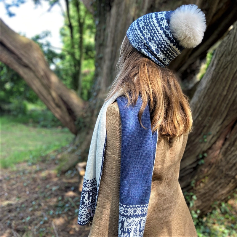 woman wearing blue fair isle patterned hat with pom pom