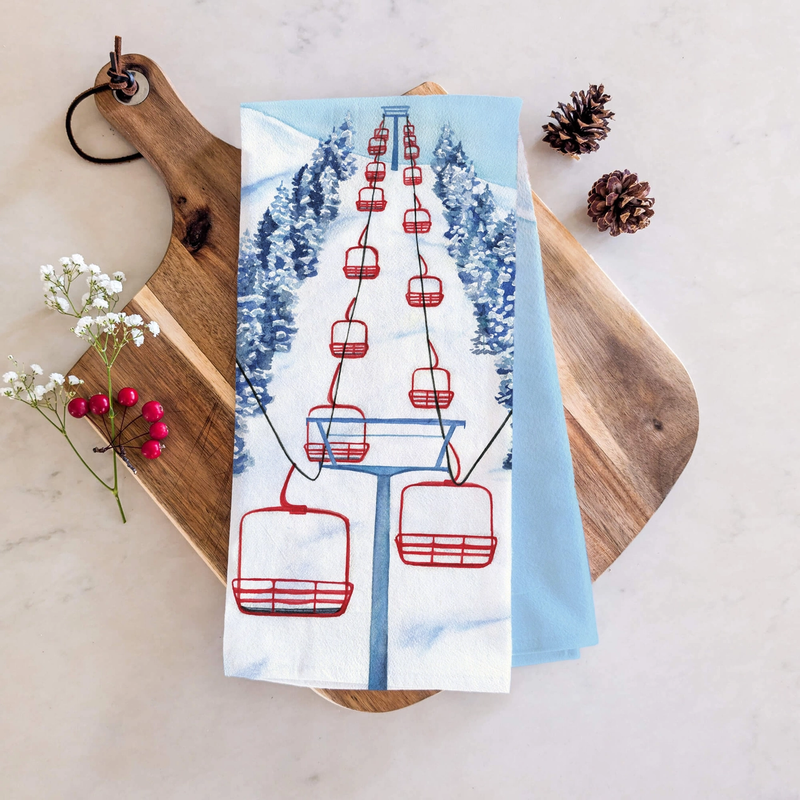 Tea towel with. red ski lift design on wooden board