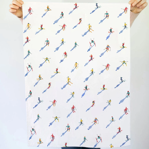 Tea towel with a pattern of small skiers on a white background