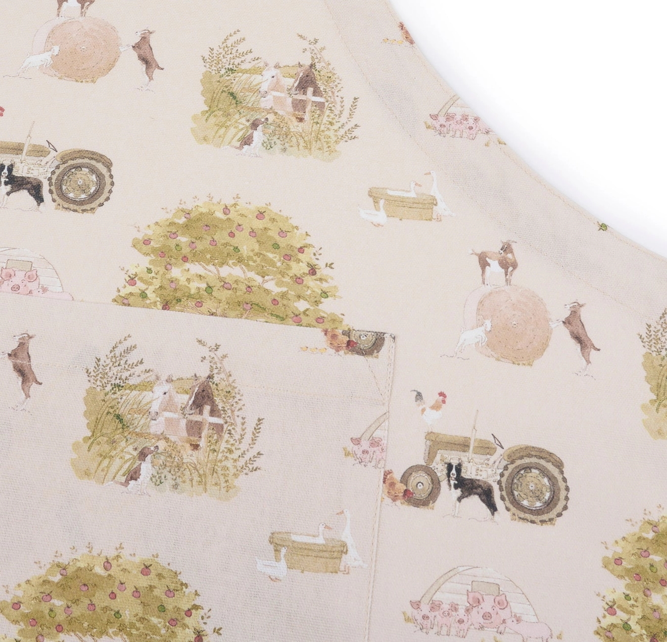 Apron with farm-themed pattern featuring tractors, animals, and fields.