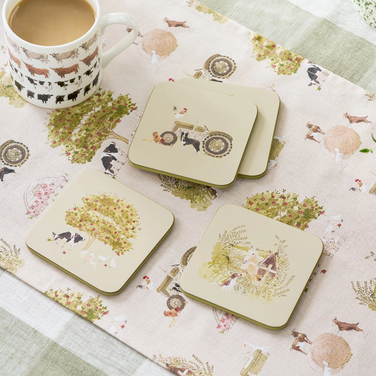 Set of coasters with farm-themed designs on a matching placemat and tablecloth.