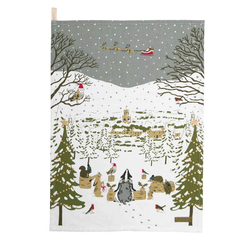 Festive tea towel with Santa Claus in a sleigh, trees, and animals in a snowy landscape.