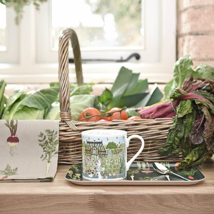 Mug, napkin, and tray with garden design on a table with vegetables in the background