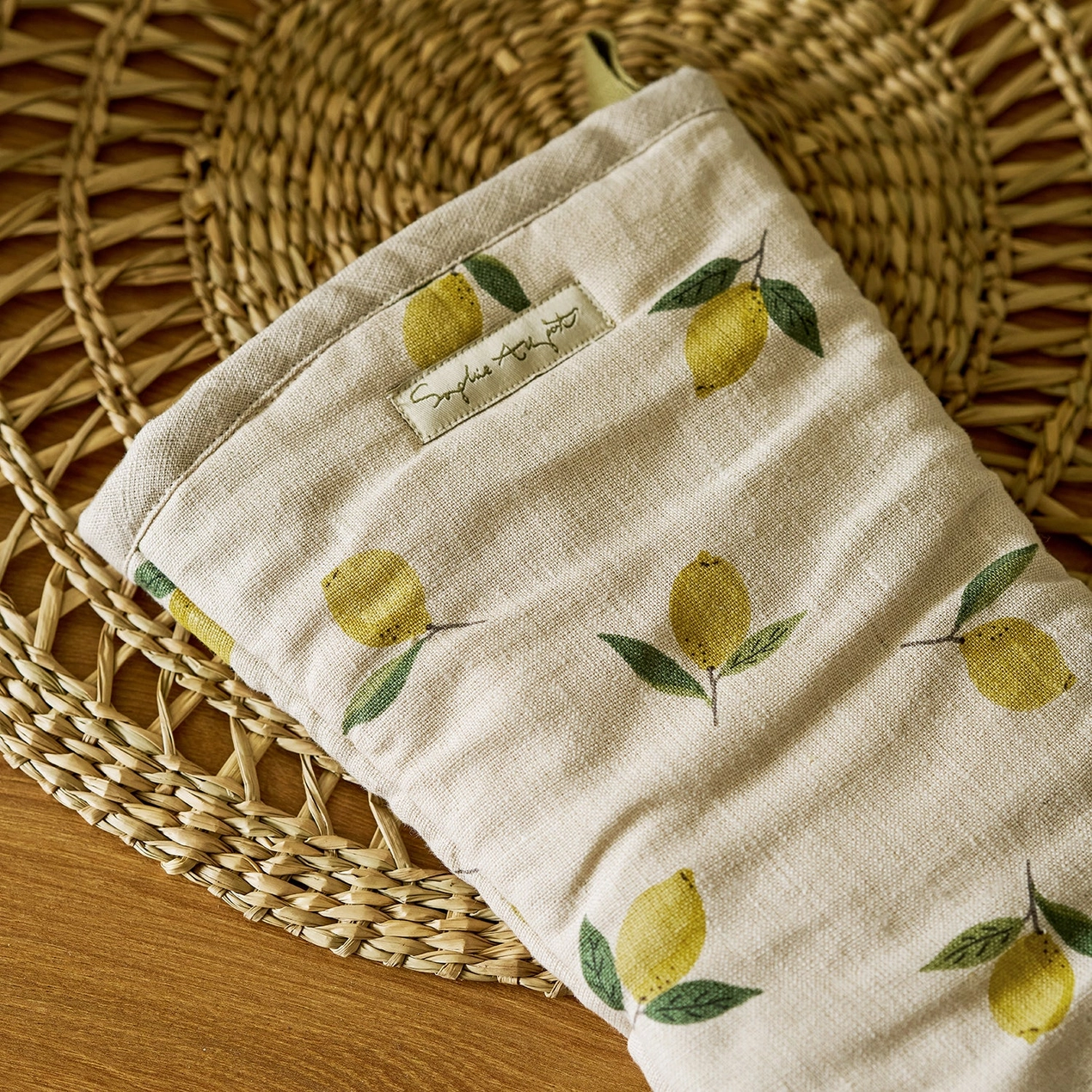 Oven mitt with lemon pattern on a woven mat
