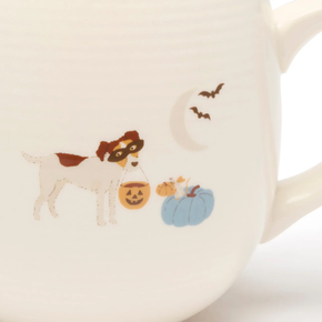 Mug with Halloween-themed design featuring a dog, pumpkins, and bats on a beige background.