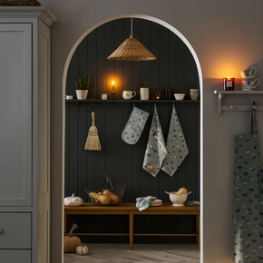 Archway into a kitchen with shelves, decorative items, and a broom.