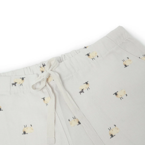 Light gray pajama pants with a pattern of small black and white sheep on a white background