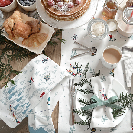 Festive table setting with ski themed tea towel, napkins, and mug