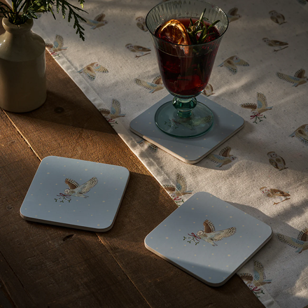 Set of coasters with owl design on a tablecloth with a floral pattern