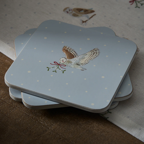 Stack of coasters with owl design on a snowy background