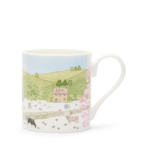 A white fine bone china mug with a spring cottage scene design, including a cottage, blossoming trees, and baby animals.