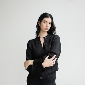 Woman wearing a black cardigan against a plain background