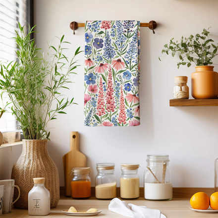 Floral towel hanging on a wooden rack with kitchen items and plants in the background