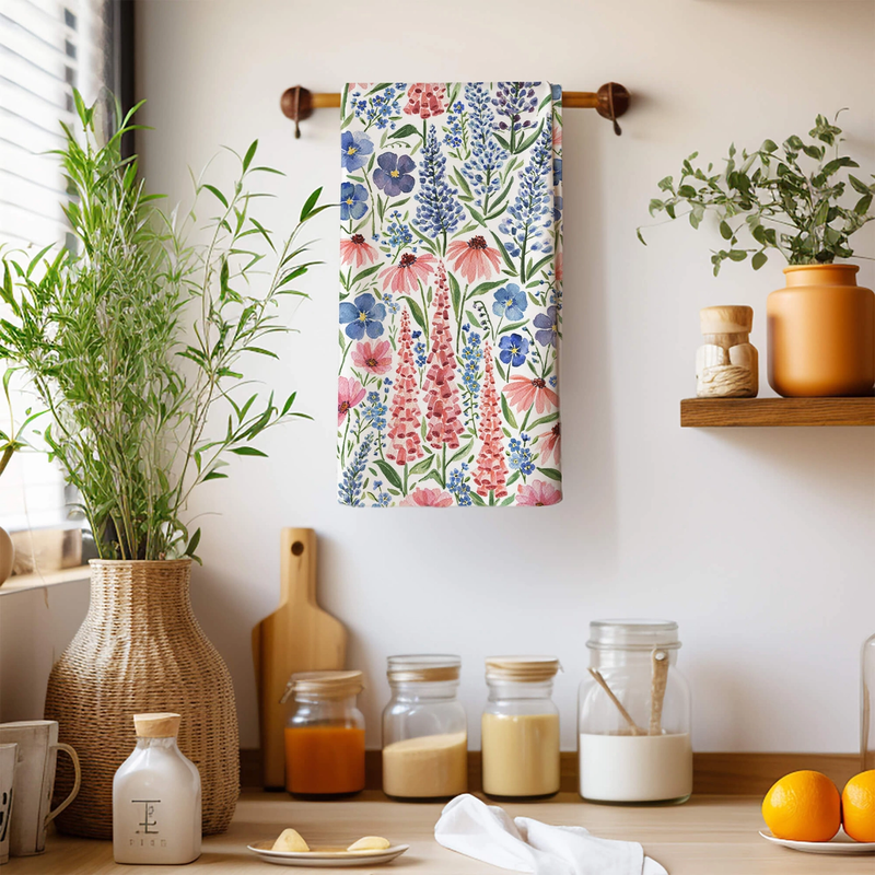 Floral towel hanging on a wooden rack with kitchen items and plants in the background