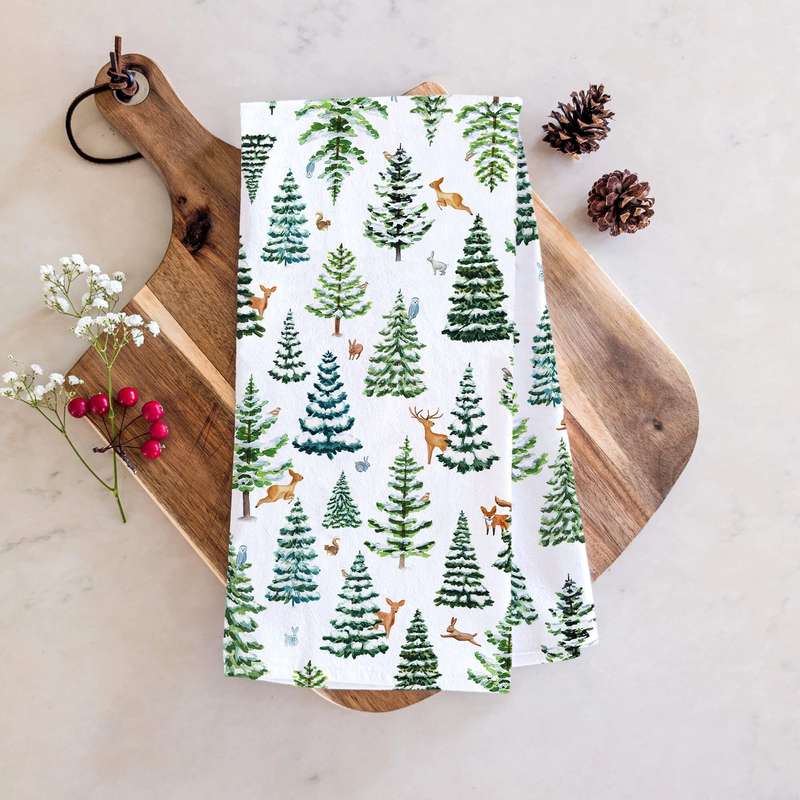 Kitchen towel with forest pattern on a wooden cutting board