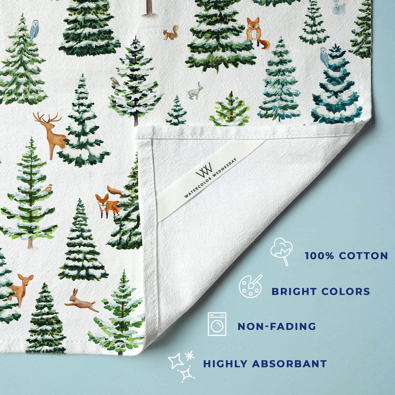Folded tea towel with forest pattern on a light blue background