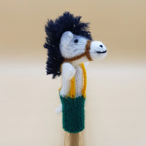 Knitted horse finger puppet on a wooden stick against a beige background