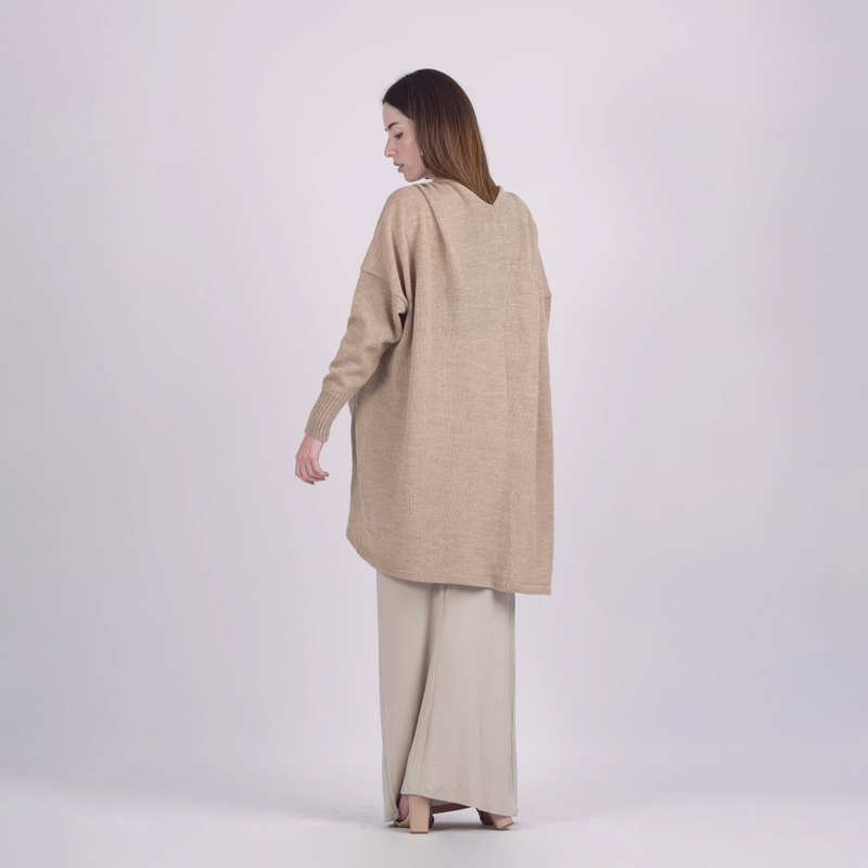 Woman wearing a beige long-sleeve top and pants on a white background