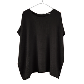 Black drapey top on a hanger against a white background