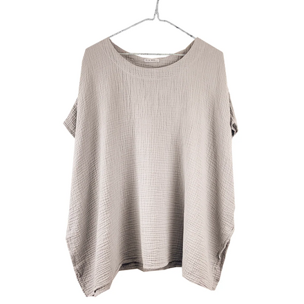 Beige drapey top on a hanger against a white background