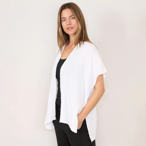 Woman wearing white gauze cardigan over black top and black