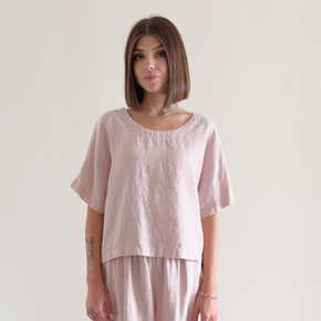 Woman wearing a light pink outfit against a plain background