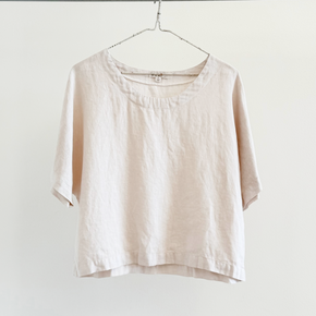 Beige blouse on a hanger against a white background