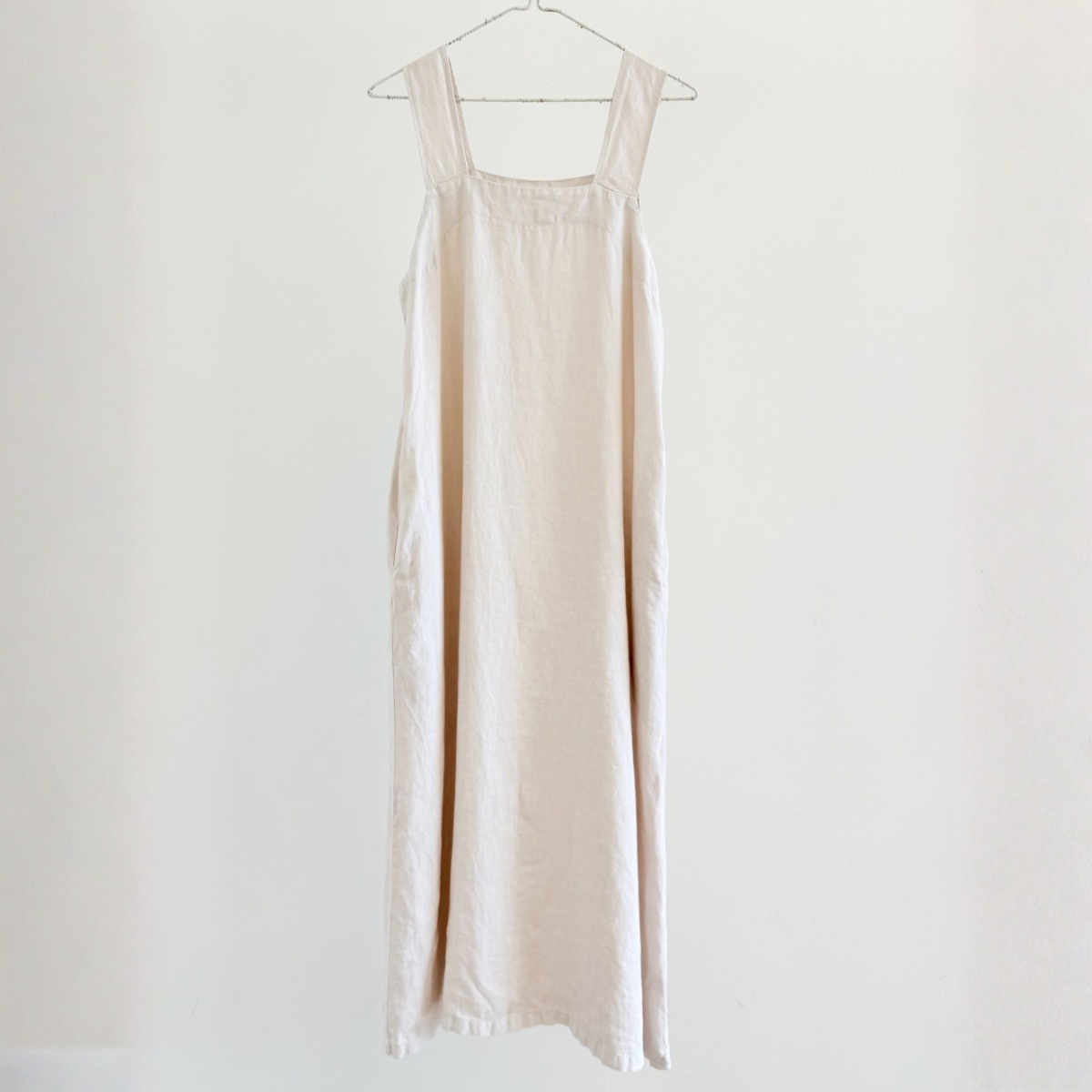 Beige dress hanging on a white background
