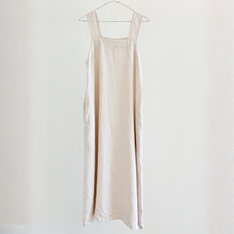 Beige dress hanging on a white background