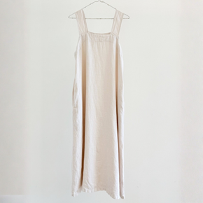 Beige dress hanging on a white background