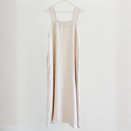 Beige dress hanging on a white background
