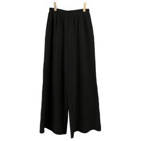 Black wide-leg pants hanging on a white background
