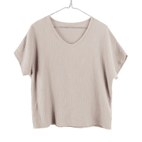 Beige ribbed t-shirt on a hanger against a white background