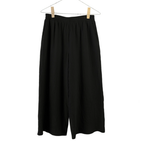 Black pants hanging on a white background